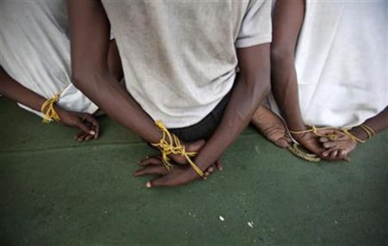 Suspected Somali pirates sit with their hands bound by rope on the deck of an Indian Coast Guard vessel in Mumbai