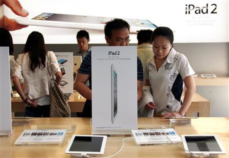 Customers look at various iPad 2 products during the China launch at an Apple Store in central Beijing
