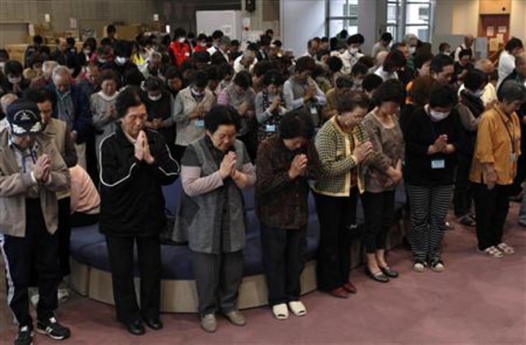 Evacuees observes a moment of silence for those who were killed by the March 11 earthquake and tsunami, at an evacuation shelter in Soma, Fukushima prefecture