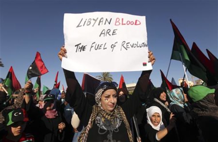 A protester holds a sign while attending a rally near the courthouse in Benghazi
