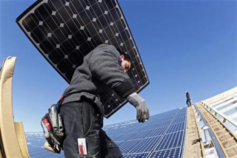 Workers install solar panels at a farm