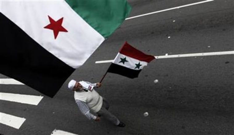 Arab demonstrator holds a Syrian flag in a demonstration to protest the military crackdown in Syria, in downtown Sao Paulo
