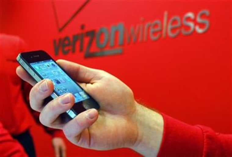 Employee holds out an iPhone for a customer at a Verizon store in Boston