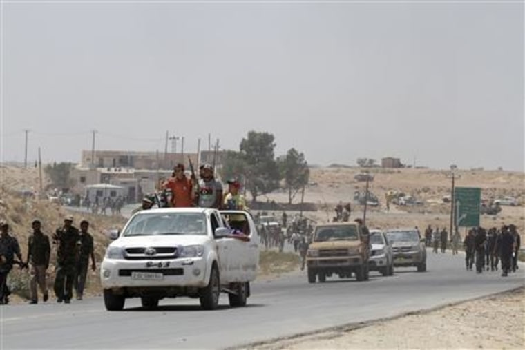 Rebel fighters enter the village of Al-Qawalish