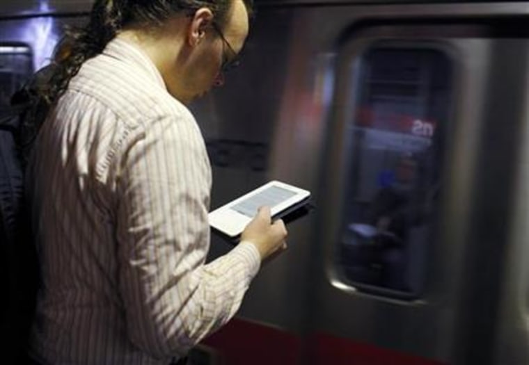 A commuter reads on his Kindle e-reader