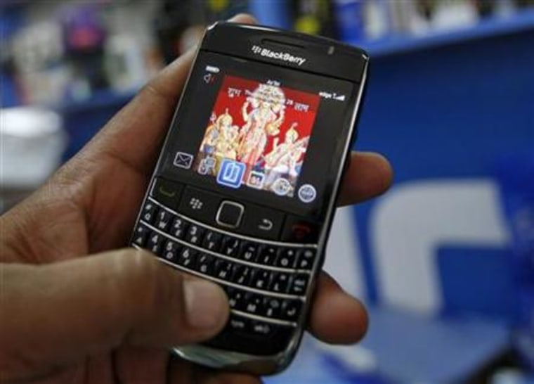 A customer holds a BlackBerry handset at a mobile phone shop in Ahmedabad