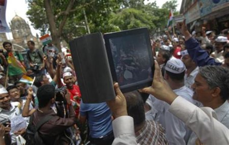 A man uses an iPad to shoot video of supporters of veteran Indian social activist Anna Hazare during an anti-government rally in Mumbai