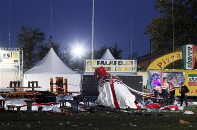 Police officers look at wreckage of a tent which collapsed folowing a heavy storm at the Pukkelpop outdoor music festival near Hasselt,