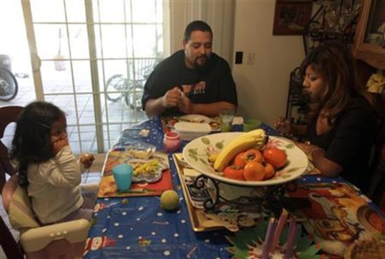 Thelma Zambrano eats lunch with her husband Jesse Torres and daughter Vida Torres, 2, at their home in Santa Ana, California