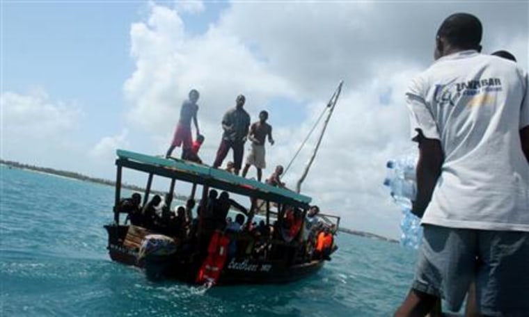 Deck hands aboard the tourist diving vessel Kisi throw bottles of water to the parched survivors of the Zanzibar ferry that sunk off the coast of Pemba overnight