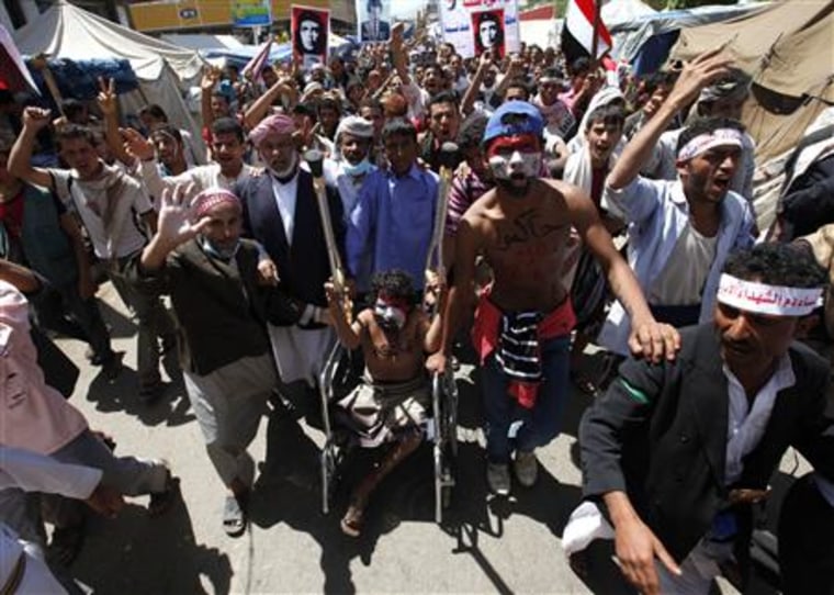 Anti-government protesters, two with anti-Saleh slogans on their chest, chant slogans during a rally demanding the ouster of Yemeni President Saleh in Sanaa