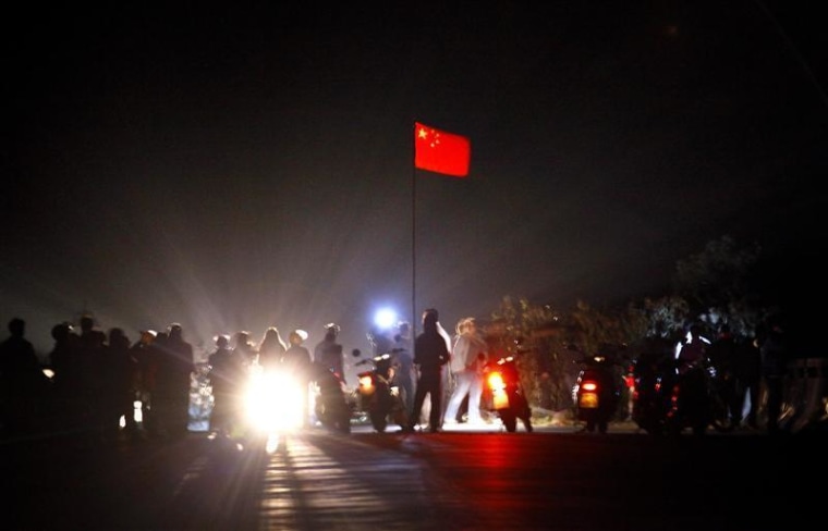 The Chinese national flag flies from a make-shift mast as residents of the village of Wukan in Lufeng county, Guangdong province remove a barricade