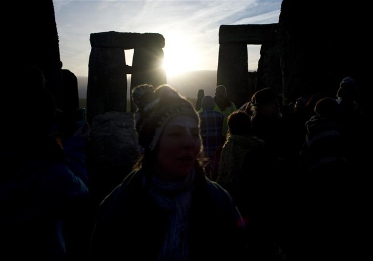 Revellers watch as the sun rises at Stonehenge on Salisbury plain in southern England