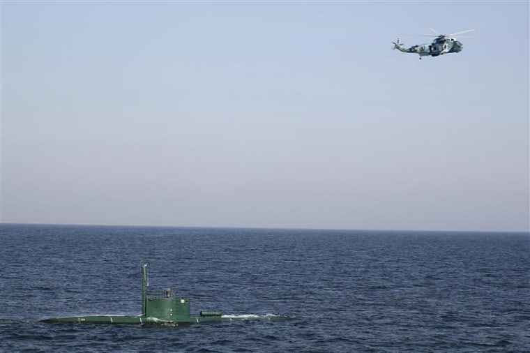 Military helicopter flies over submarine during Velayat-90 war games by Iranian navy in Strait of Hormuz in southern Iran