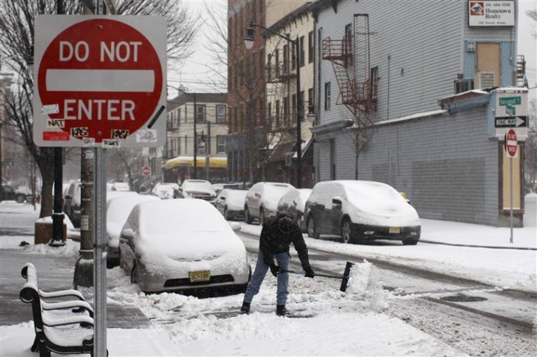A man cleans the street during a snow storm in Jersey City