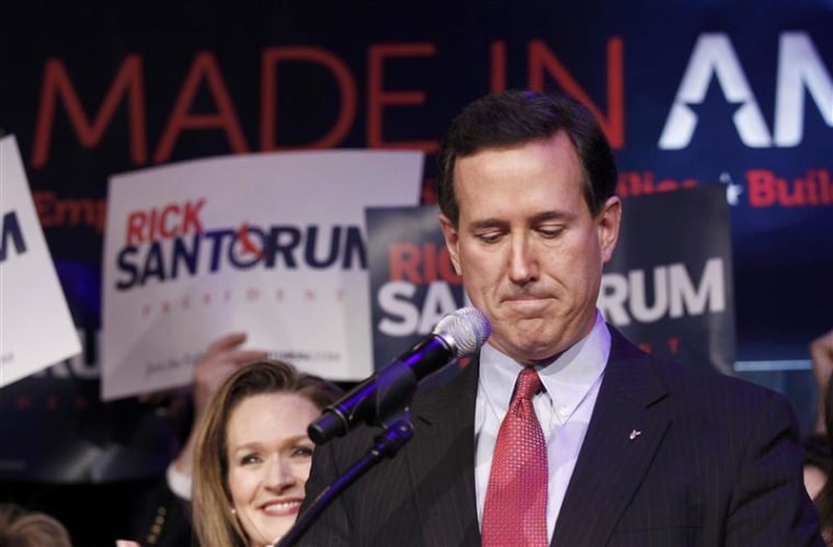 U.S. Republican presidential candidate Rick Santorum pauses while addressing supporters with his wife Karen at his Michigan primary night rally in Grand Rapids