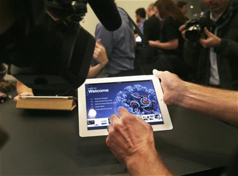 A man shows an example of an iBook textbook on an iPad after a news conference introducing a digital textbook service in New York
