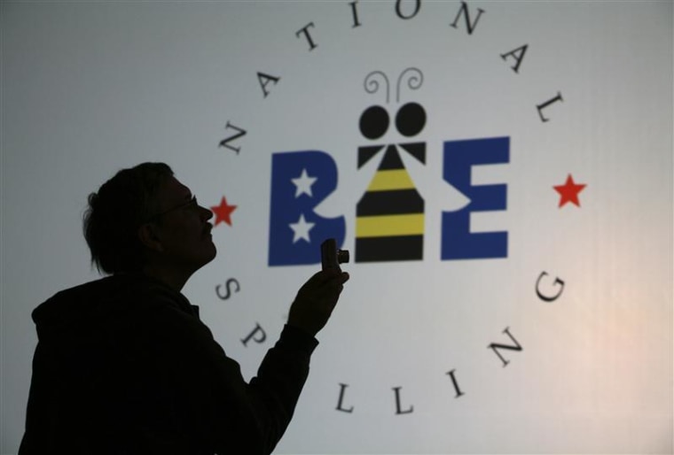 A spectator takes photos of contestants on stage before the start of the second phase of round three of the 2011 Scripps National Spelling Bee at the Gaylord National Resort and Convention Center at National Harbor