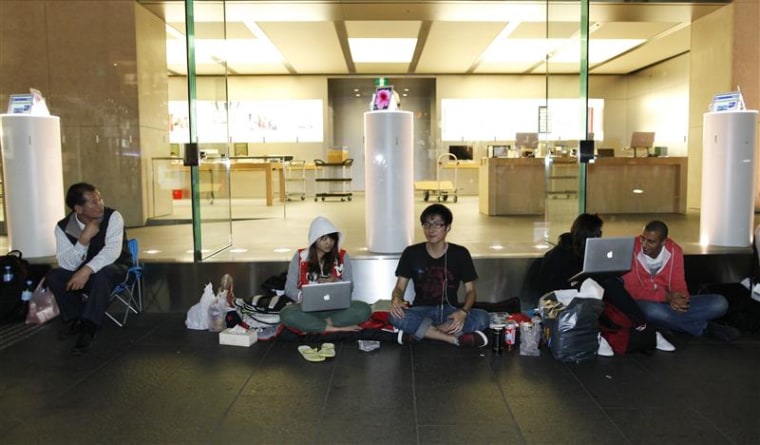 People waiting to buy a new iPad tablet queue in front of an Apple store in Sydney