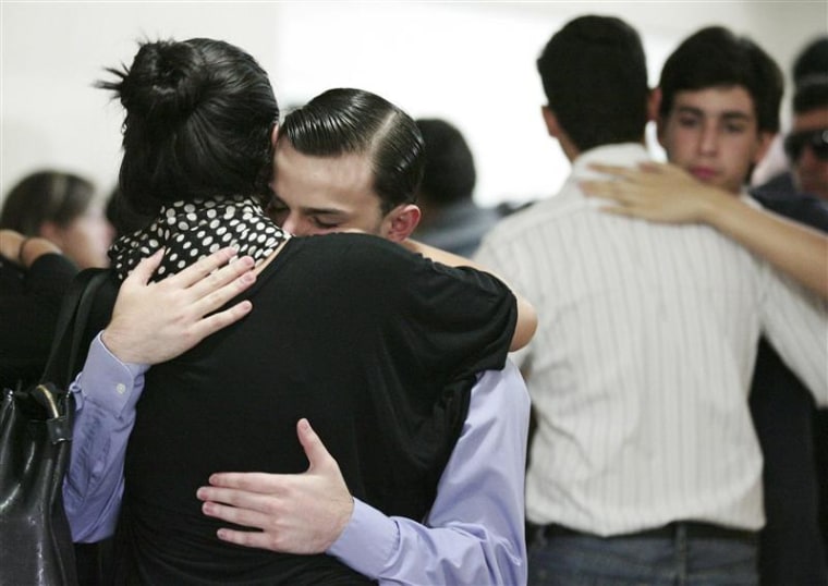 Relatives of Karen Berendique comfort each other during her funeral in Maracaibo