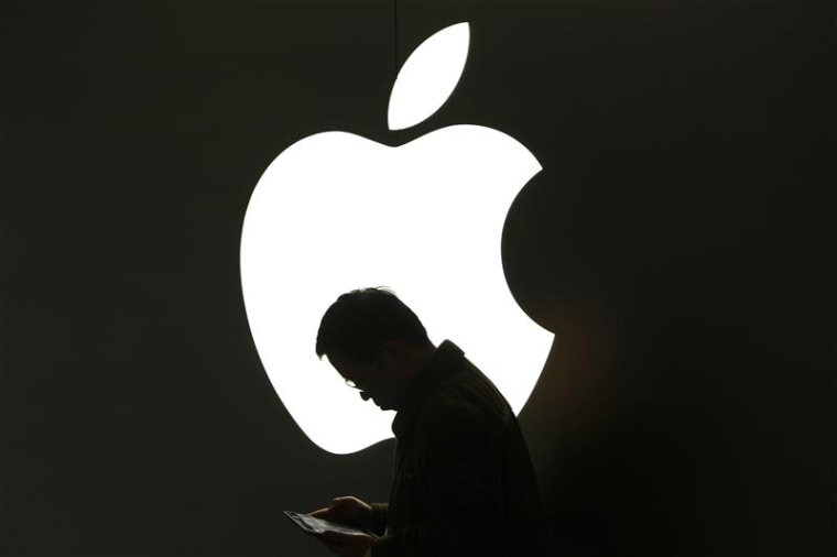 File photo of a man looking at his Apple iPad in front an Apple logo in downtown Shanghai