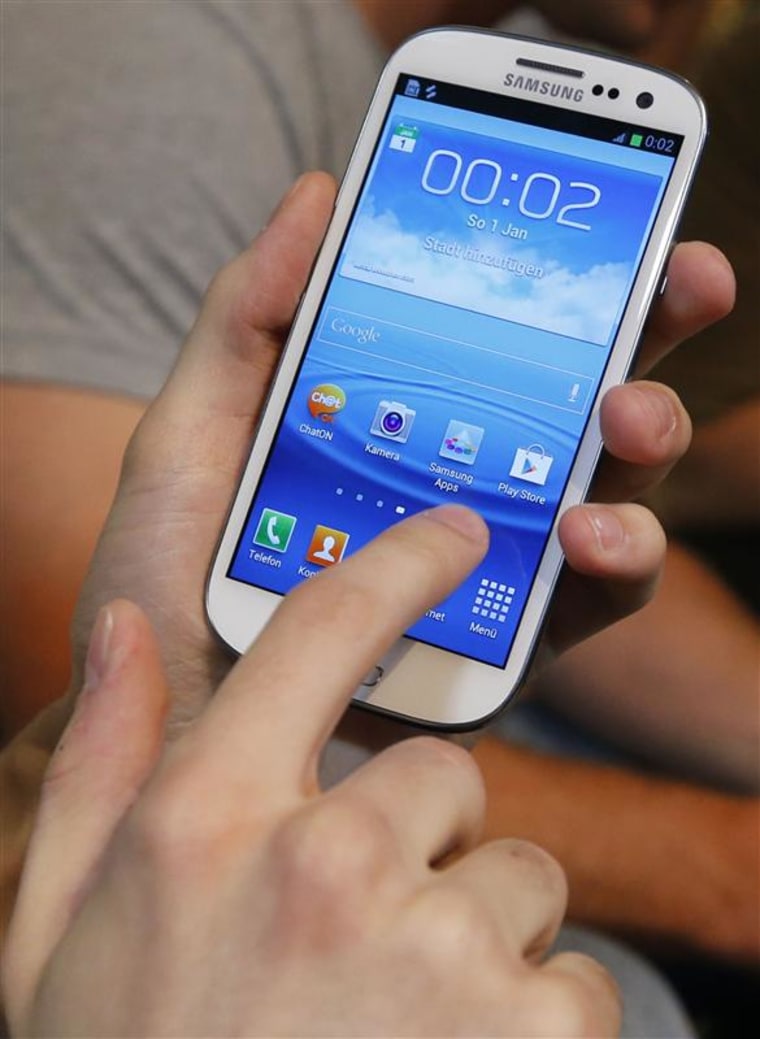 A customer uses a Samsung Electronics' Samsung Galaxy SIII smartphone during a late night sale event in Berlin