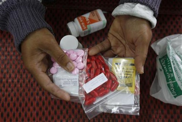 A HIV-infected patient displays medicine at a hospital in Payao province