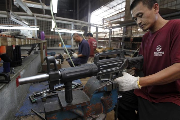A former illegal gunsmith inspects a newly assembled multi-action shotgun at Shooters Arms, a gun manufacturing company exporting different kinds of weapons to other countries, in Cebu city