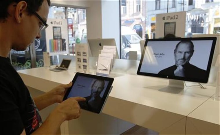 A customer looks at the screen of an iPad in an Apple store in central Prague