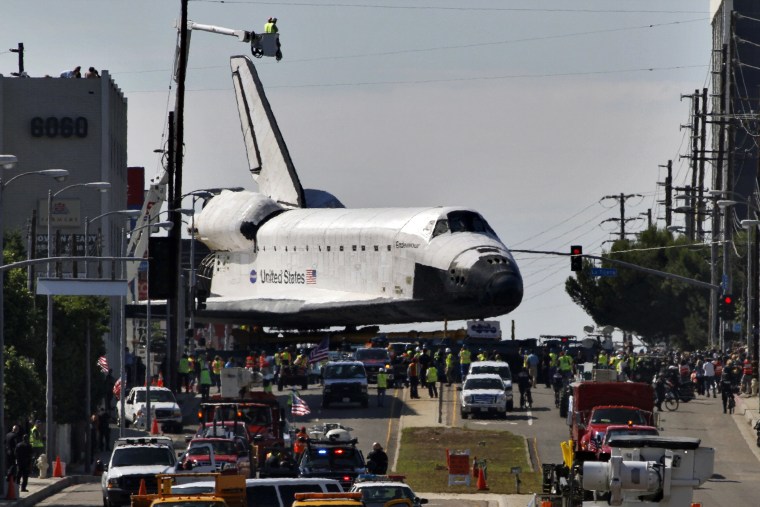 Space Shuttle Endeavour makes a right turn onto Machester Avenue in Los Angeles, California