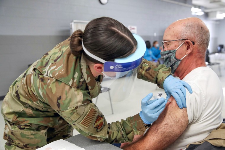 Image: A member of the Illinois Air National Guard administers a Pfizer Covid-19 vaccine to Richard Persha at a vaccination center established at the Triton College in River Grove, Ill., on Feb. 3, 2021.