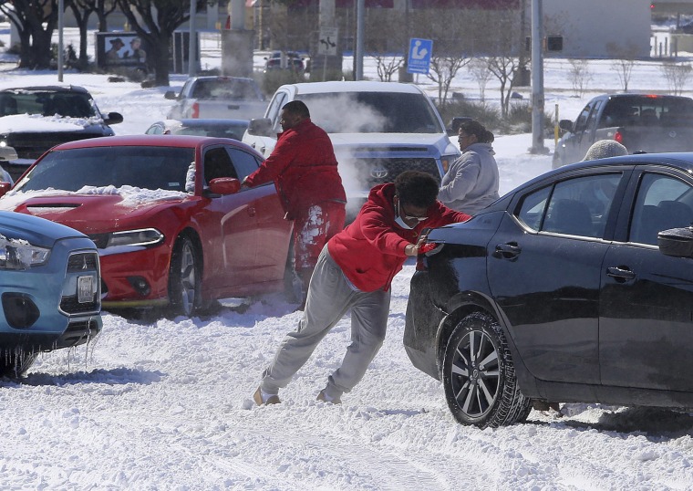 Image: People push a car free after spinning out in the snow Monday, Feb. 15, 2021 in Waco, Texas