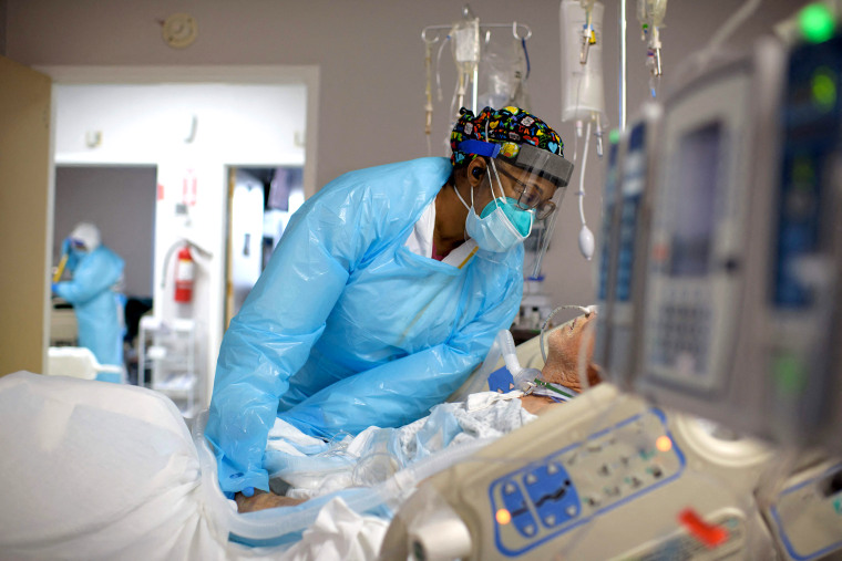 Image: A healthcare worker comforts a patient in the Covid-19 ward at United Memorial Medical Center in Houston on Dec. 4, 2020.