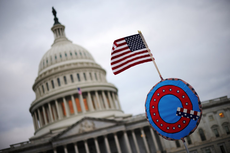 Image: A U.S. flag with a symbol from the group QAnon outside the U.S. Capitol on Jan. 6, 2021.