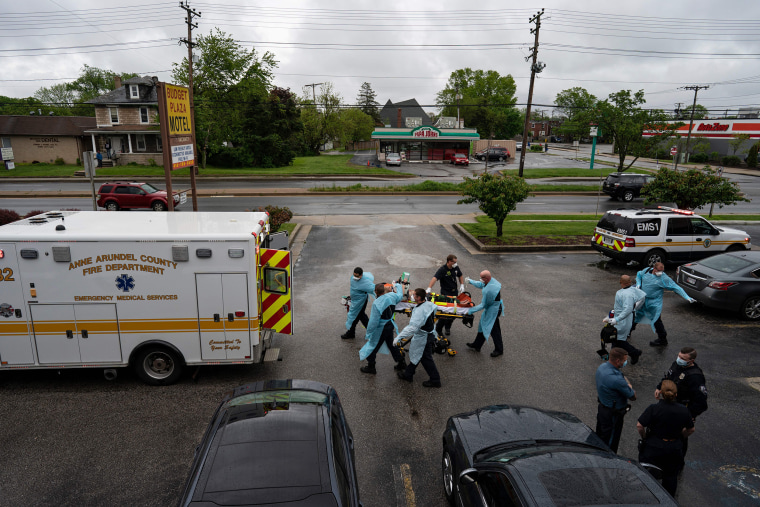 Firefighters and paramedics transport a patient after responding to a call for a cardiac arrest from a drug overdose in Brooklyn, Md., on May 6, 2020.