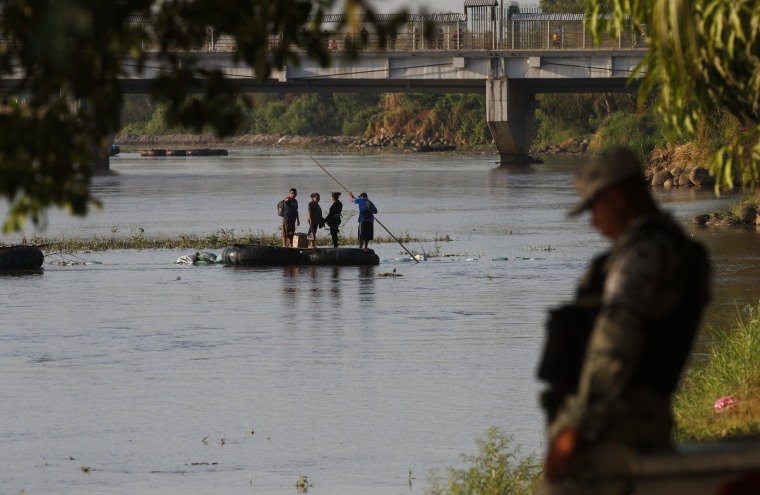 People travel across the Suchiate River from Guatemala to Mexico, as Mexican immigration agents enforce limits on all but essential travel at its shared border, near Ciudad Hidalgo, Mexico, on March 22, 2021.
