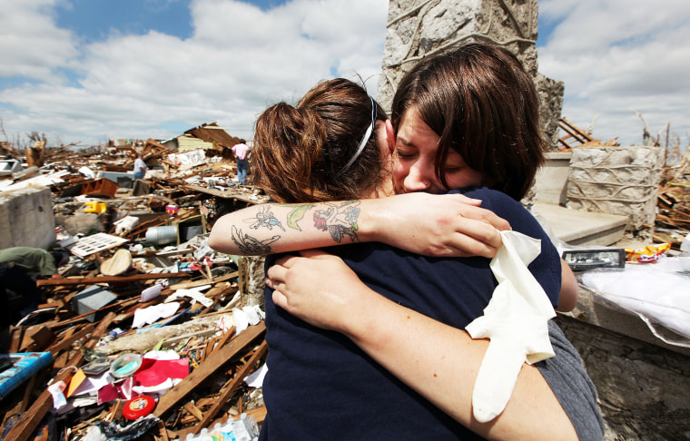 Shandie Spencer, right, hugs a volunteer while recovering items from the basement of her destroyed home, where she was trapped after riding out the massive tornado that killed at least 132 people, on May 26, 2011, in Joplin, Mo.