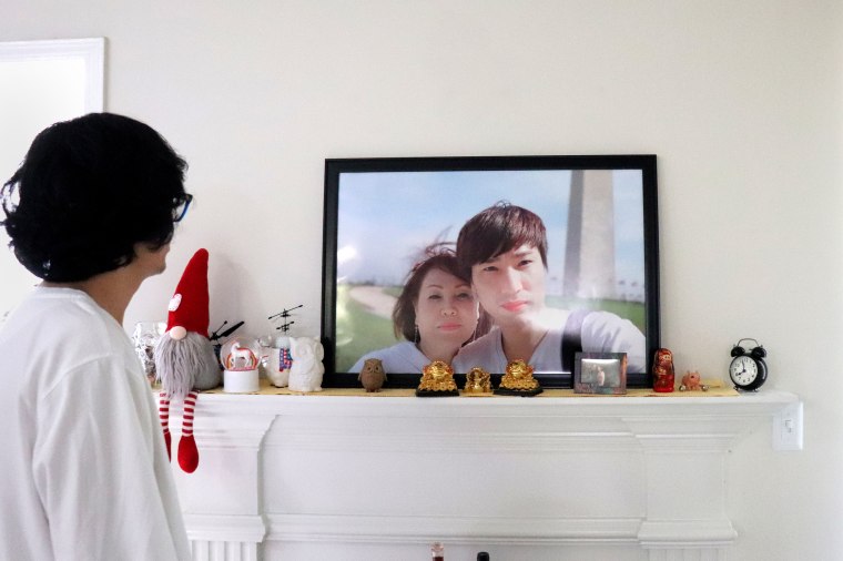 Soon Chung Park's husband Gwangho Lee looks at a photo of the two of them in their home.