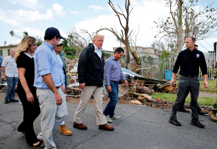 Image: President Trump walks past hurricane wreckage as he visits areas damaged by Hurricane Maria in Guaynabo, Puerto Rico