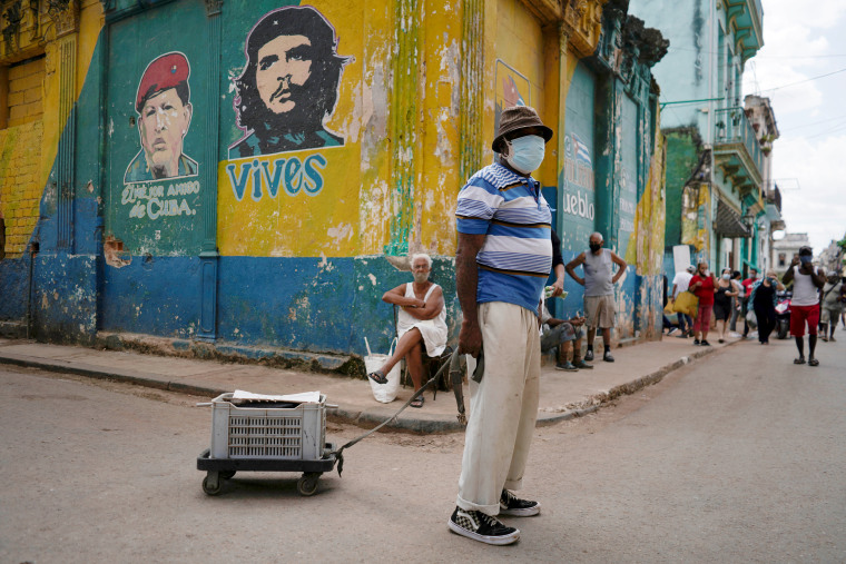 Image: Trumpet player Carlos Sanchez announces his fan reparations services as he walks in downtown Havana on March 15, 2021.