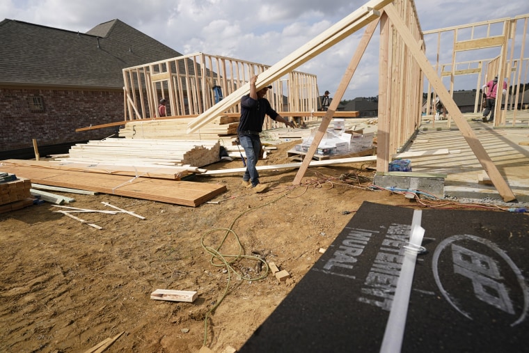 A workman carries beams at a new housing site in Madison County, Miss., on March 16, 2021.