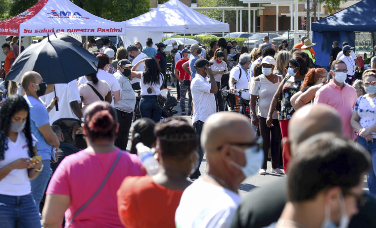 People wait in line for hours at a pop-up COVID-19 vaccination site in the parking lot of Bravo Supermarket in Orlando, Fl., on April 9, 2021. The one-day mobile site offered 400 doses of the one-shot Johnson and Johnson vaccine.