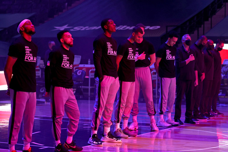 The Brooklyn Nets stand on the court for the National Anthem before the game against the Minnesota Timberwolves on April 13, 2021 at Target Center in Minneapolis.