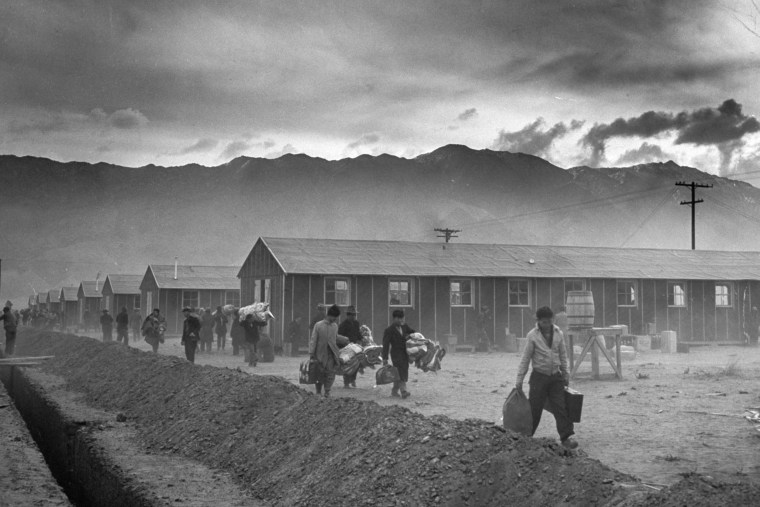 Image: The first group of 82 Japanese-Americans arrive at the Manzanar internment camp carrying their belongings in suitcases and bags, in Owens Valley, Calif., on March 21, 1942.