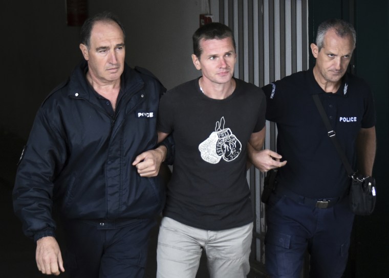 A Russian man identified as Alexander Vinnik, center, is escorted by police officers from the courthouse in Thessaloniki, Greece, on Sept. 29, 2017. Vinnik was convicted of laundering $160 million in criminal proceeds through a cryptocurrency exchange called BTC-e.