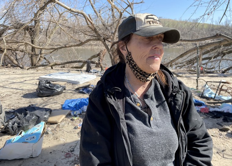 Image: Terri Domer visits the riverside encampment in Cedar Rapids, where she weathered last August's derecho.