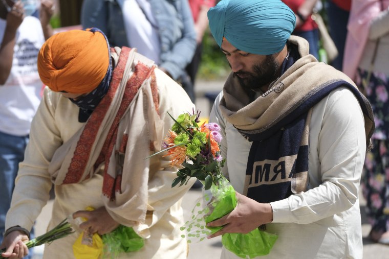 Image: Family, friends and community members attend a vigil in Indianapolis, on April 18, 2021 to remember the victims of a mass shooting at a FedEx facility.