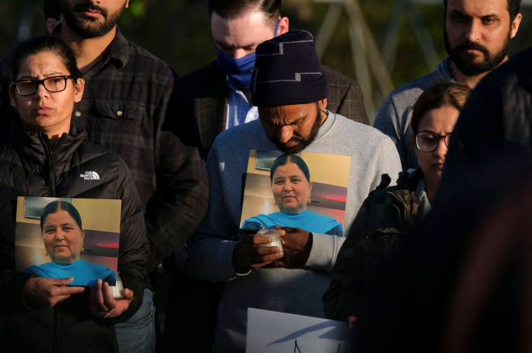 Image: Family members hold a photo of their loved one during a candlelight vigil in Krannert Park in Indianapolis on April 17, 2021, to remember the victims of a mass shooting at a FedEx facility.