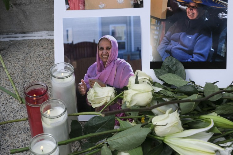 Image: Family, friends and community members lay flowers and candles during a vigil in Indianapolis,  on April 18, 2021 to remember the victims of a mass shooting at a  FedEx facility.