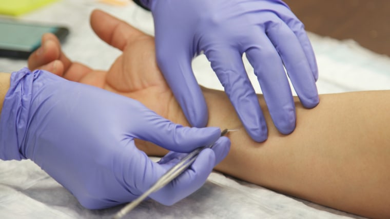 Mary Prunicki takes a skin sample from a firefighter to test for toxins.